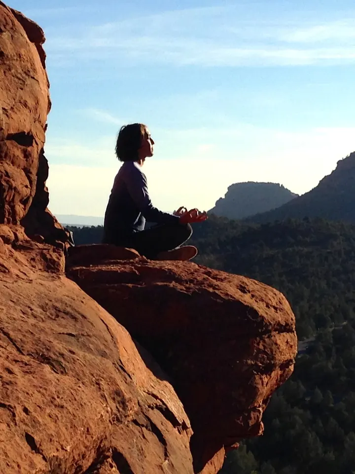 Walter Greene meditating on a red rock ledge above a canyon